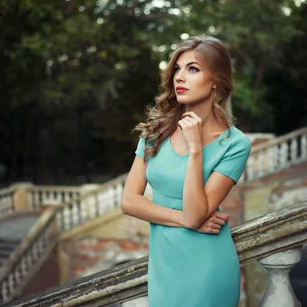 Retrato de estilo de vida al aire libre de una chica joven y bonita, vestida de azul sobre fondo urbano. Imagen tonificada de color creativo . —  Fotos de Stock