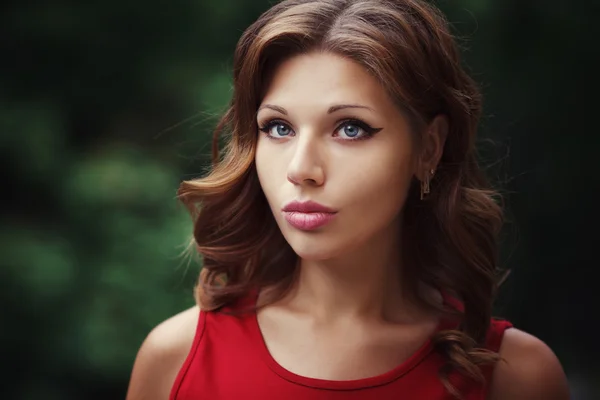 Retrato de estilo de vida al aire libre de una chica joven y bonita posando en la escalera, usando un vestido rojo sobre fondo urbano . —  Fotos de Stock