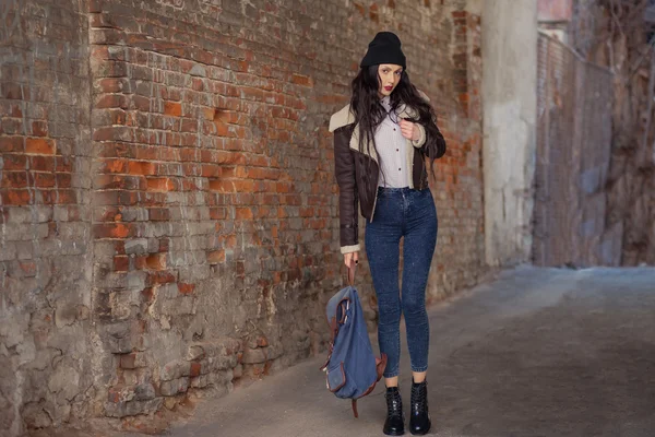 Outdoor lifestyle portrait of pretty young girl, wearing in hipster swag grunge style on urban background. Wearing hat and jeans with backpack. Spring fashion woman. Toned style instagram filters. — 스톡 사진