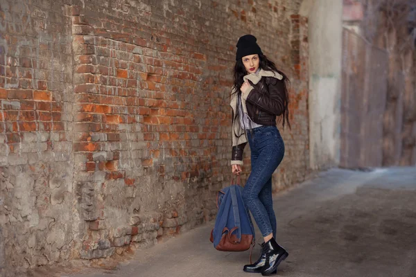 Outdoor lifestyle portrait of pretty young girl, wearing hipster swag grunge style on urban background. Wearing hat and jeans with backpack. Spring fashion woman. Toned style instagram filters. — 스톡 사진