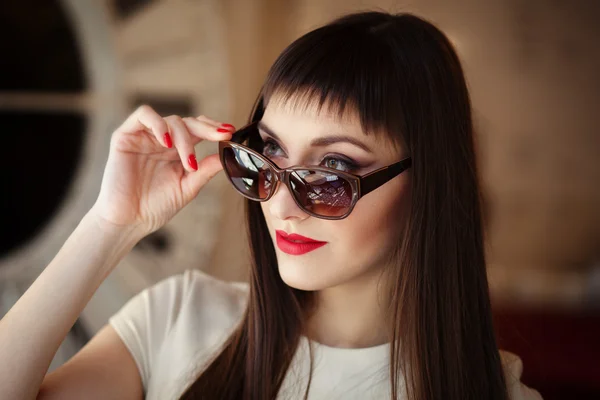 Närbild mode vacker kvinna porträtt bär solglasögon med röd Gel Polish manikyr. Smink modell. — Stockfoto