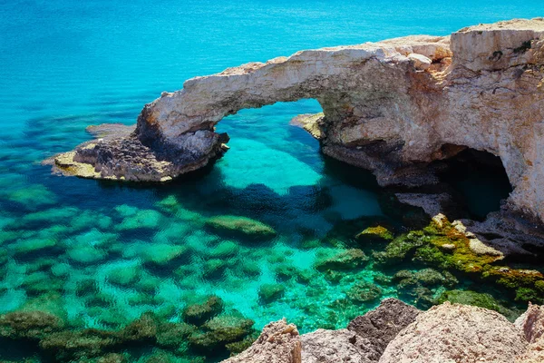 Piękny naturalny łuk skalny w pobliżu Ayia Napa, Cavo Greco i Protaras na wyspie Cypr, Morze Śródziemne. Legendarny most kochanków. Niebieski zielony na morze i słoneczny dzień. — Zdjęcie stockowe