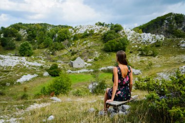 Evin yıkıntıları bakarak güzel genç bir kadın. Karadağ, Avrupa.