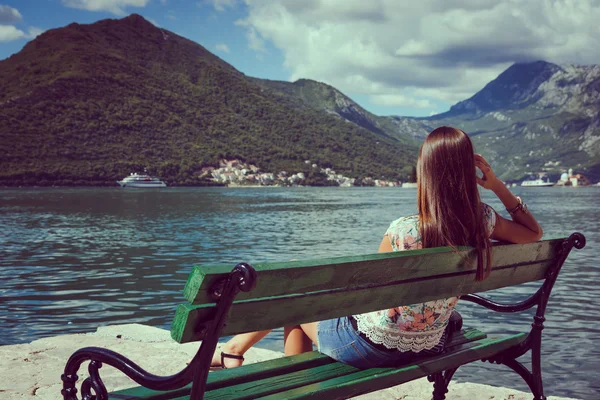 Beautiful young woman looking and waiting at the seacoast. Sunny day. Montenegro, Europe. Retro style toning image. — Stock Photo, Image