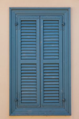 Bej duvarda kapalı mavi pencere