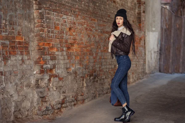 Outdoor lifestyle portrait of pretty young girl, wearing hipster swag grunge style on urban background. Wearing hat and jeans with backpack. Spring fashion woman. Toned style instagram filters. — 스톡 사진