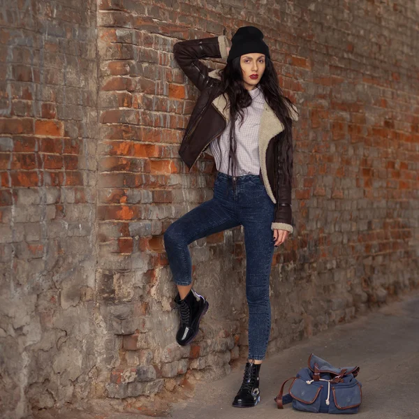 Outdoor lifestyle portrait of pretty young girl, wearing hipster swag grunge style on urban background. Wearing hat and jeans with backpack. Spring fashion woman. Toned style instagram filters. — 스톡 사진