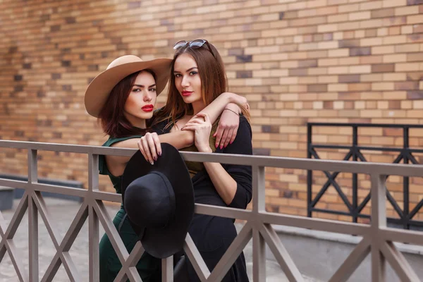 Belles femmes de la mode posant. Style de vie à la mode portrait urbain sur fond de ville. Filles portant dans le style vêtements, chapeaux et accessoires — Photo