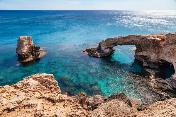 Piękny naturalny łuk skalny w pobliżu Ayia Napa, Cavo Greco i Protaras na wyspie Cypr, Morze Śródziemne. Legendarny most kochanków. Niebieski zielony na morze i słoneczny dzień. — Zdjęcie stockowe