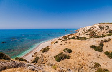 Panoramik manzara Petra tou Romiou (Yunan kaya), Paphos, Kıbrıs Adası, Akdeniz Aphrodite's efsanevi doğum yeri. Harika mavi yeşil deniz ve güneşli bir gün.