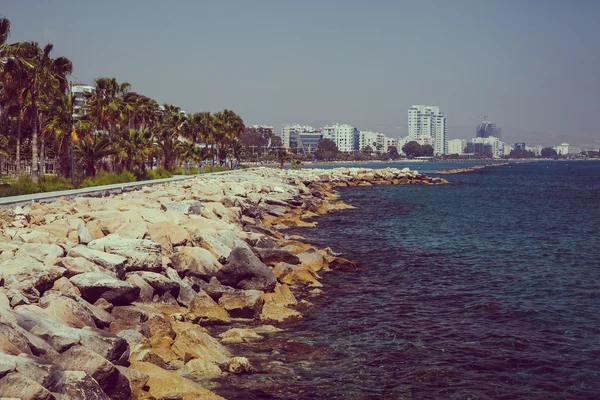 Costa y paseo marítimo en Limassol, isla Chipre, Europa, Mar Mediterráneo. Día soleado brillante y agua azul y cielo. Imagen retro vintage tonificada, simulación de película . —  Fotos de Stock