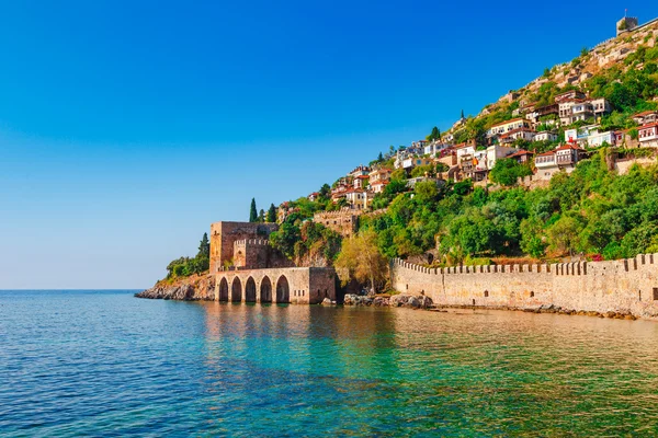 Paesaggio di antico cantiere navale vicino alla torre Kizil Kule nella penisola di Alanya, distretto di Antalya, Turchia, Asia. Famosa destinazione turistica con alte montagne. Fa parte dell'antico Castello. Estate brillante da — Foto Stock