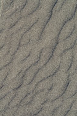 Volkanik gri kum desen bir Beach yaz aylarında closeup