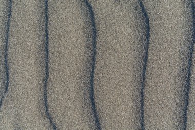 Volkanik gri kum desen bir Beach yaz aylarında closeup