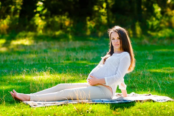 Unga gravid kvinna koppla av i park utomhus, graviditet — Stockfoto