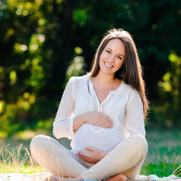 Jeune femme enceinte se détendre dans le parc à l'extérieur, grossesse en bonne santé — Photo