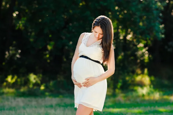 Young pregnant woman relaxing in park outdoors, healthy pregnancy — Stock Photo, Image