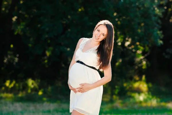 Young pregnant woman relaxing in park outdoors, healthy pregnancy — Stock Photo, Image