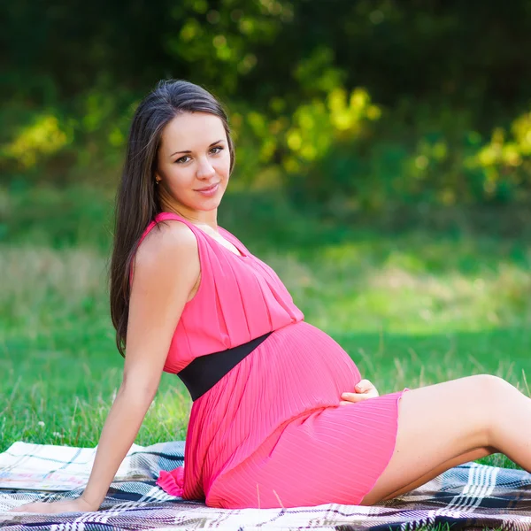 Young pregnant woman relaxing in park outdoors, healthy pregnancy — Stock Photo, Image