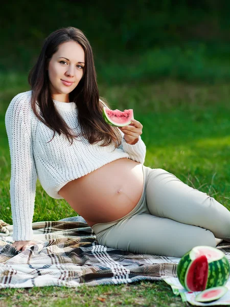 Jovem mulher grávida relaxante no parque ao ar livre, gravidez saudável . — Fotografia de Stock