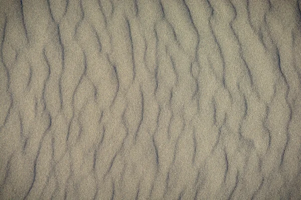 Closeup de padrão de areia vulcânica de uma praia no verão — Fotografia de Stock