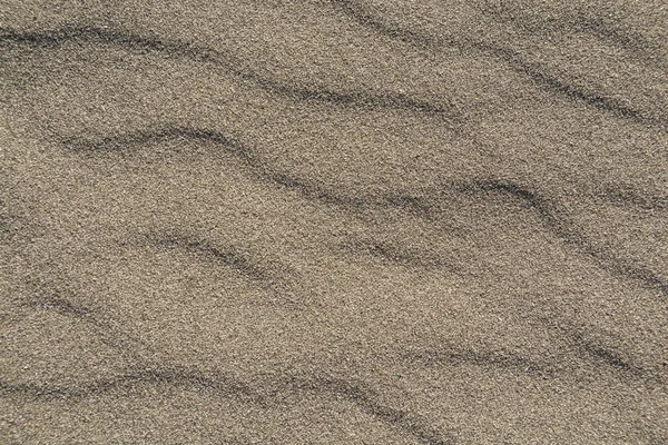 Closeup of volcanic sand pattern of a beach in the summer — Stock Photo, Image