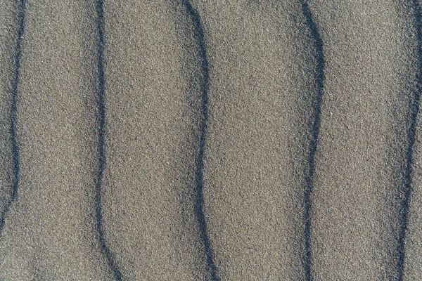 Closeup of volcanic gray sand pattern of a beach in the summer — Stock Photo, Image