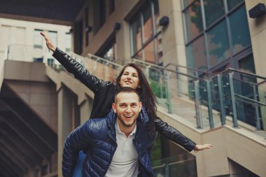 Güzel genç çift modern kentsel arka plan açık havada bir tarihte aşık. Gülümseyen ve sarılma. Rustik yakışıklı ve gündelik elbise esmer güzel kadın sakallı. Retro film tonlama görüntü