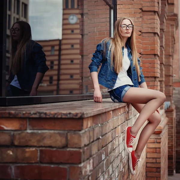 Style de vie de mode en plein air portrait de jolie jeune fille assise, portant dans hipster swag grunge style fond urbain . — Photo