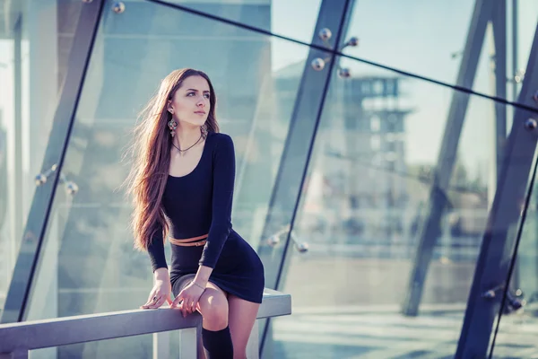 Mode buiten portret van sexy mooie vrouw met bruin haar dragen in zwarte jurk, slang en hoge hakken. Die zich voordeed op creatieve stedelijke achtergrond. — Stockfoto