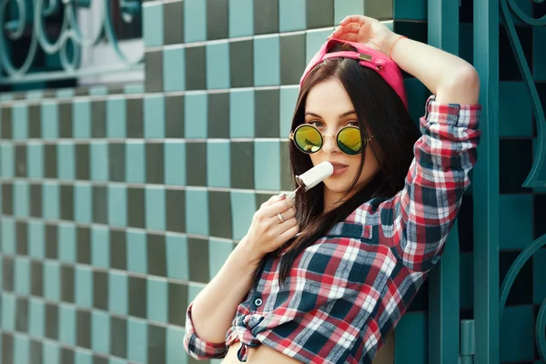 Young hipster style girl outdoor in creative sunglasses and eati — Stock Photo, Image