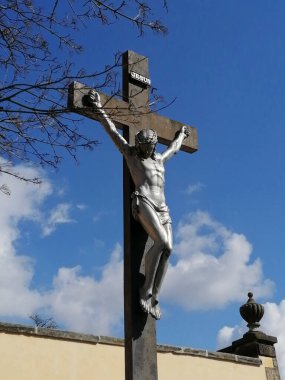 Çarmıha gerilmiş çarmıha gerilmiş İsa 'nın metal heykeli. Paskalya mevsiminin renkli fotoğrafı.