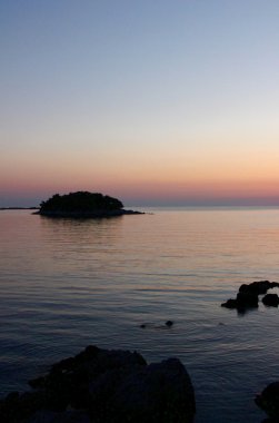 Adriyatik Denizi üzerinde gün batımı. Ufukta küçük ada