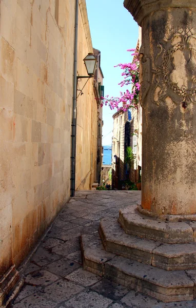 Rua de Korcula. Coluna velha no beco — Fotografia de Stock