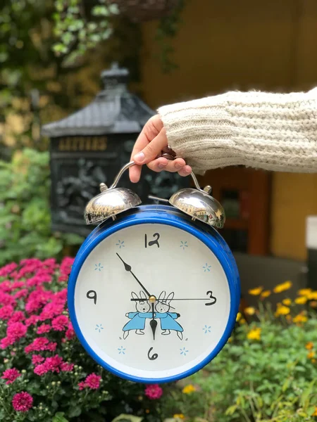 person holding a vintage clock