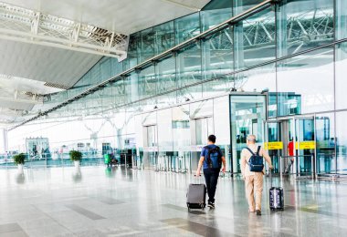 HANOI, VİETNAM 27 OCT 2019 - Hanoi Uluslararası Havalimanı 'ndaki (Noi Bai) kalkış salonunun önünde yürüyen yolcu.