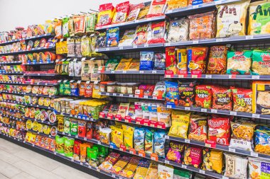 HANOI, VIETNAM - 1.2021 Mart - Bir markette rafta çok sayıda abur cubur ve şeker markası satışı, çeşitli atıştırmalıklar, cipsler, krakerler, süpermarket raflarında tatlı.