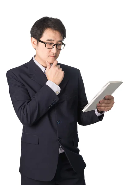 Asian businessman reading notebook or diary for checking, isolat — Stock Photo, Image