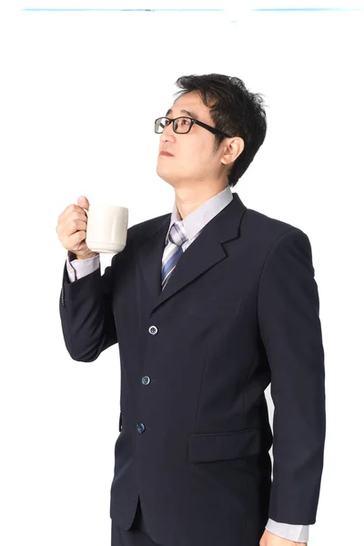 Tankeväckande asiatiska affärsman holding kopp kaffe och ser en — Stockfoto