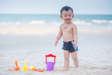 Küçük Asyalı çocuk 1 yaşında iskambil kum plaj
