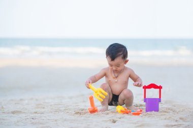 Küçük Asyalı çocuk 1 yaşında iskambil kum plaj