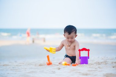 Küçük Asyalı çocuk 1 yaşında iskambil kum plaj