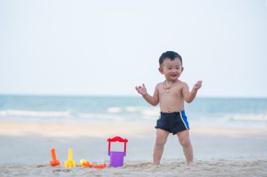 Küçük Asyalı çocuk 1 yaşında iskambil kum plaj
