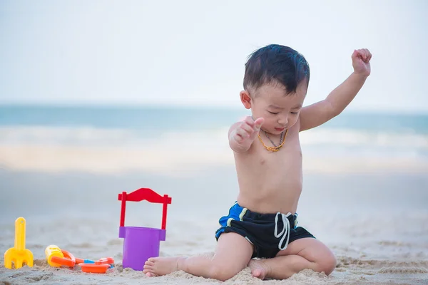 Pequeno menino asiático 1 ano de idade jogando areia na praia — Fotografia de Stock