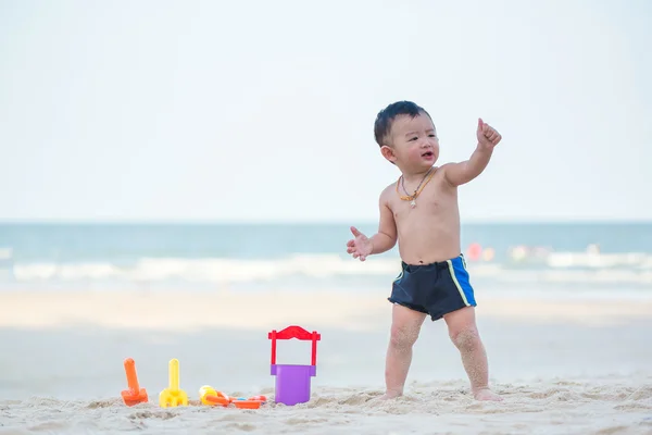 Pequeno menino asiático 1 ano de idade jogando areia na praia — Fotografia de Stock