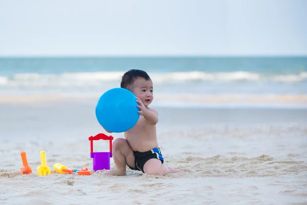 Liten asiatisk pojke 1 år gammal spelar boll på stranden — Stockfoto