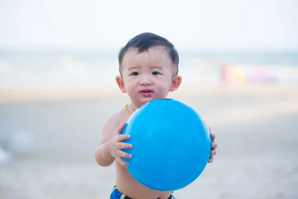 Liten asiatisk pojke 1 år gammal spelar boll på stranden — Stockfoto