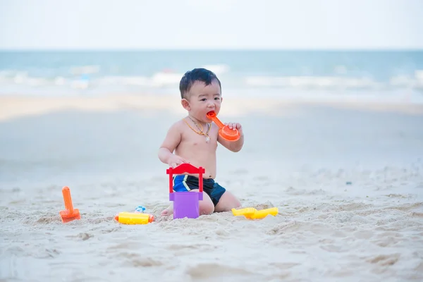 Pequeno menino asiático 1 ano de idade jogando areia na praia — Fotografia de Stock