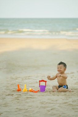Küçük Asyalı çocuk 1 yaşında iskambil kum plaj