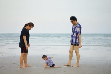 Mutlu genç Asyalı aile sahip eğlenceli yürüyüş üzerinde tropikal plaj